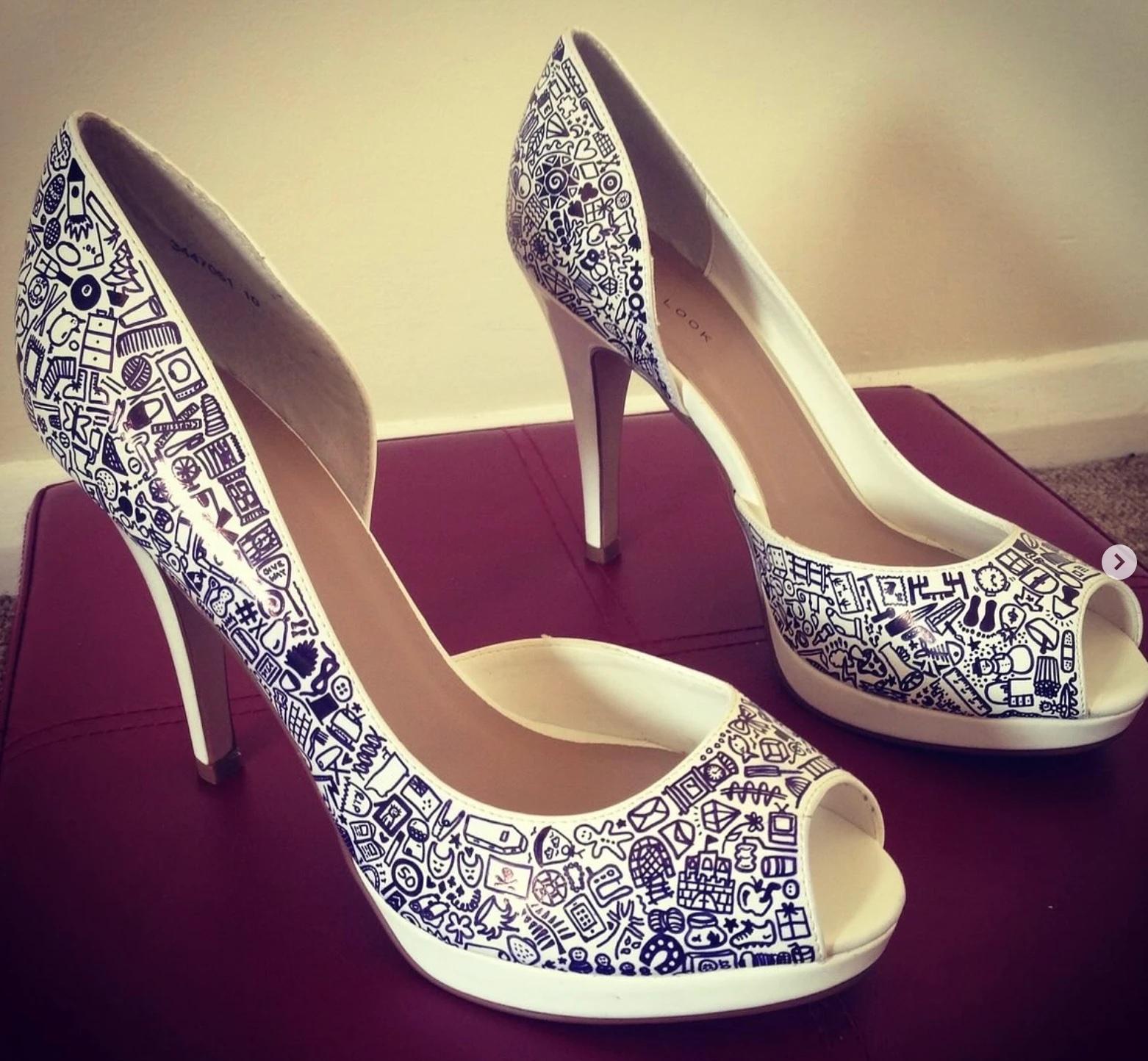 White peep-toe heels covered in hand-drawn black doodles — a custom pair for a special day