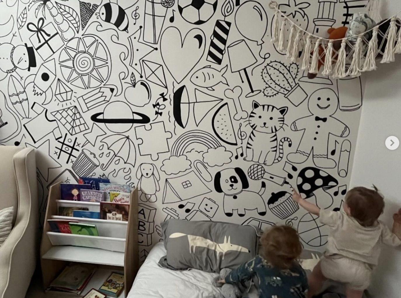 A custom black-and-white doodle mural across a child's bedroom wall