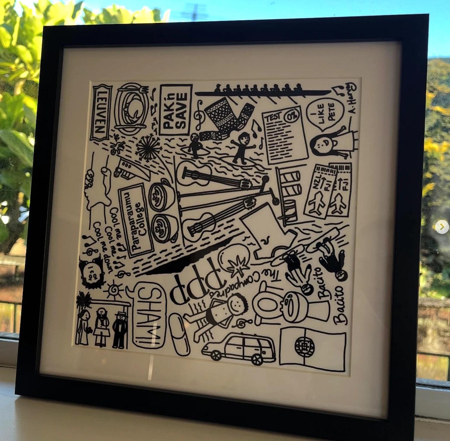 A framed square memory print — a couple's story told in dozens of hand-drawn doodles, from concert tickets to family jokes